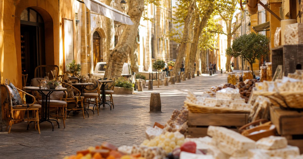 Ruelle ensoleillée d Aix-en-Provence avec terrasse de café et étal de spécialités provençales